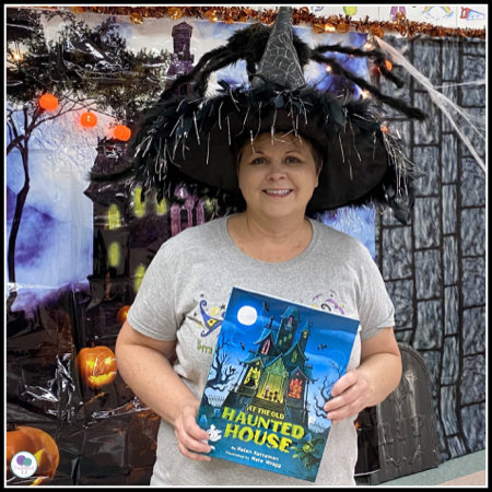 Teacher dressed as a witch reading a Halloween story. 